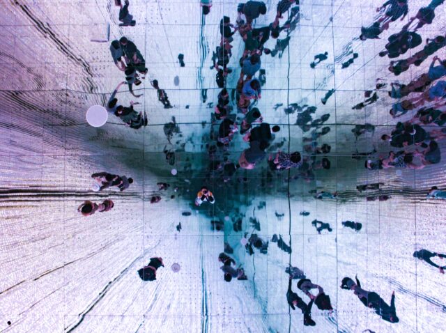 Low angle view of ceiling mirror showing people's reflection
